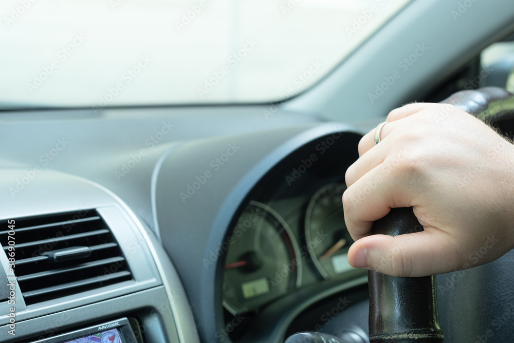 Man’s hand holding the steering wheel close-up. Selective focus. Driving concept. Man’s hand holding the steering wheel close-up. Selective focus. Driving concept.