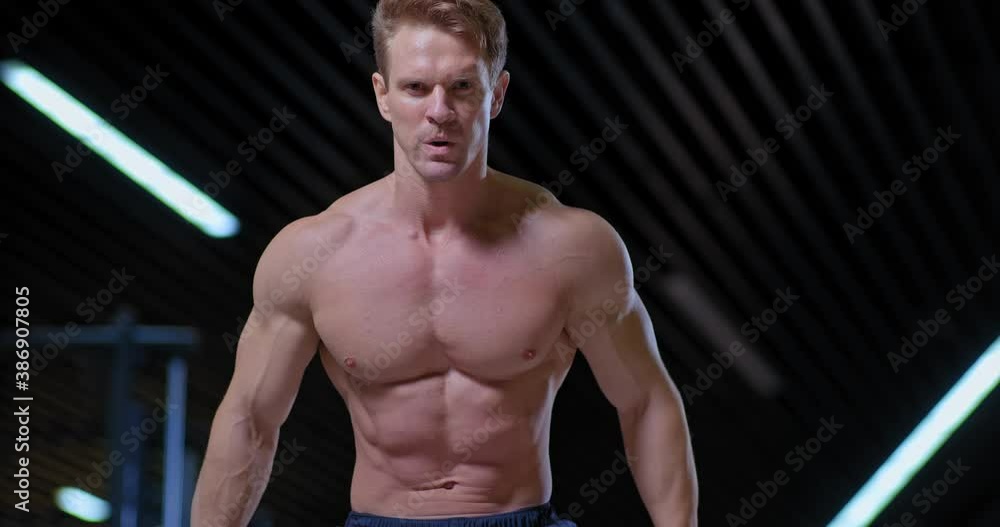 Portrait view, the athlete twists the ropes, a tense look. Inflated