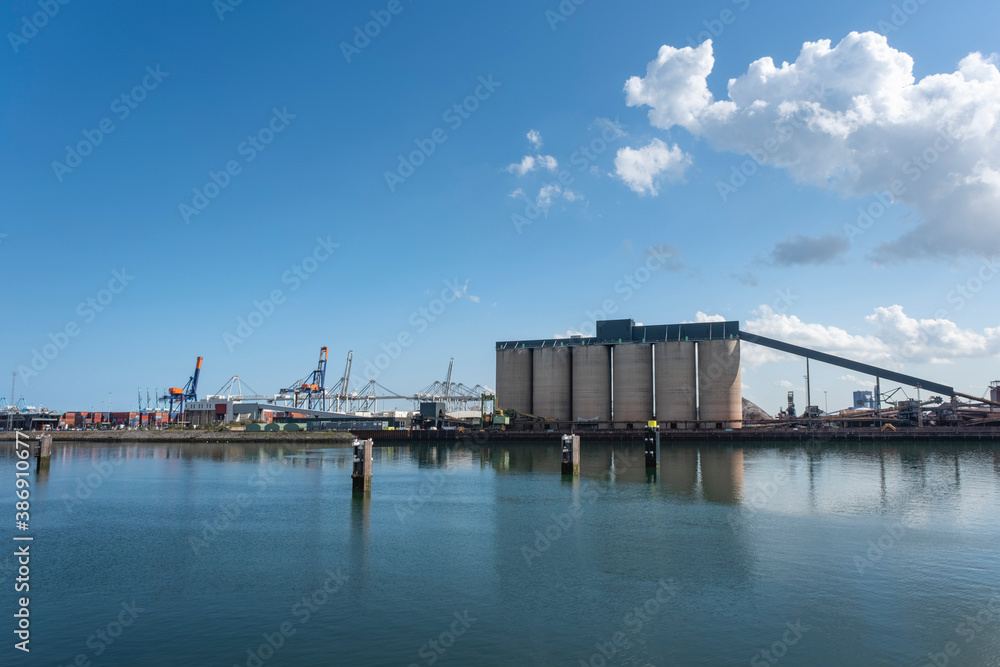 Logistics and transportation of Container Cargo ship and Cargo plane with working crane bridge in shipyard, logistic import export and transport industry background Logistics and transportation of Container Cargo ship and Cargo plane with working crane bridge in shipyard, logistic import export and transport industry background
