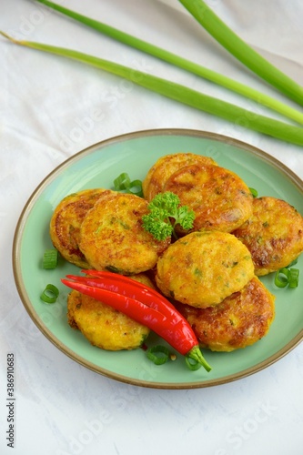 Perkedel, Indonesian fried potato minced beef patties garnish with parsley and chili in a bowl 