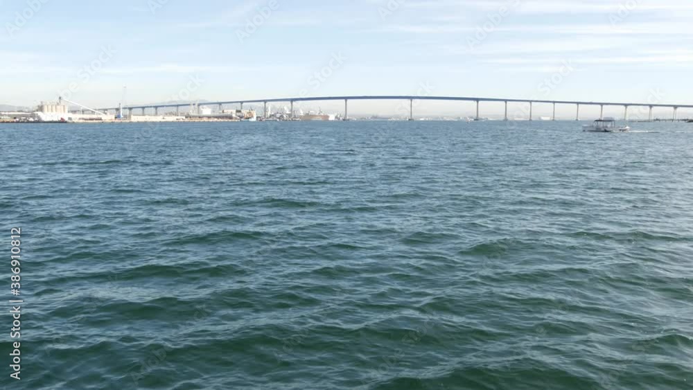 Famous Coronado automobile bridge in San Diego county, California USA. View from boat on water surface of Pacific ocean bay. Harbour in American city. Transportation infrastructure for cars over sea. Famous Coronado automobile bridge in San Diego county, California USA. View from boat on water surface of Pacific ocean bay. Harbour in American city. Transportation infrastructure for cars over sea.