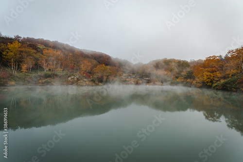 霧がかかる沼・池・湖の紅葉の風景