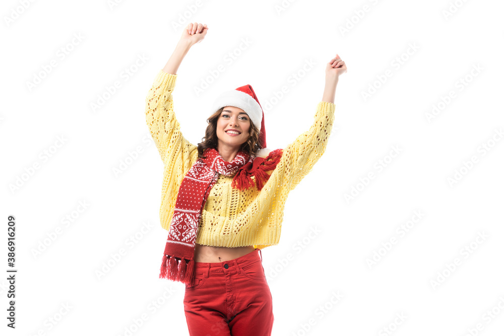 young happy woman in santa hat and red scarf standing with hands above head isolated on white young happy woman in santa hat and red scarf standing with hands above head isolated on white