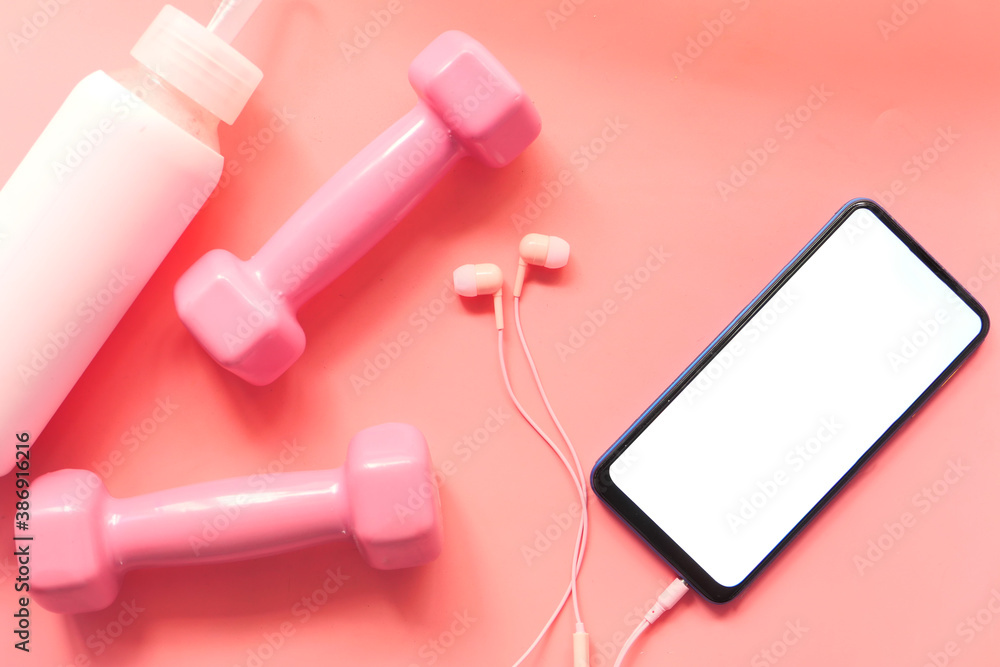 Fototapeta premium Smart phone with sports equipment on wooden floor.