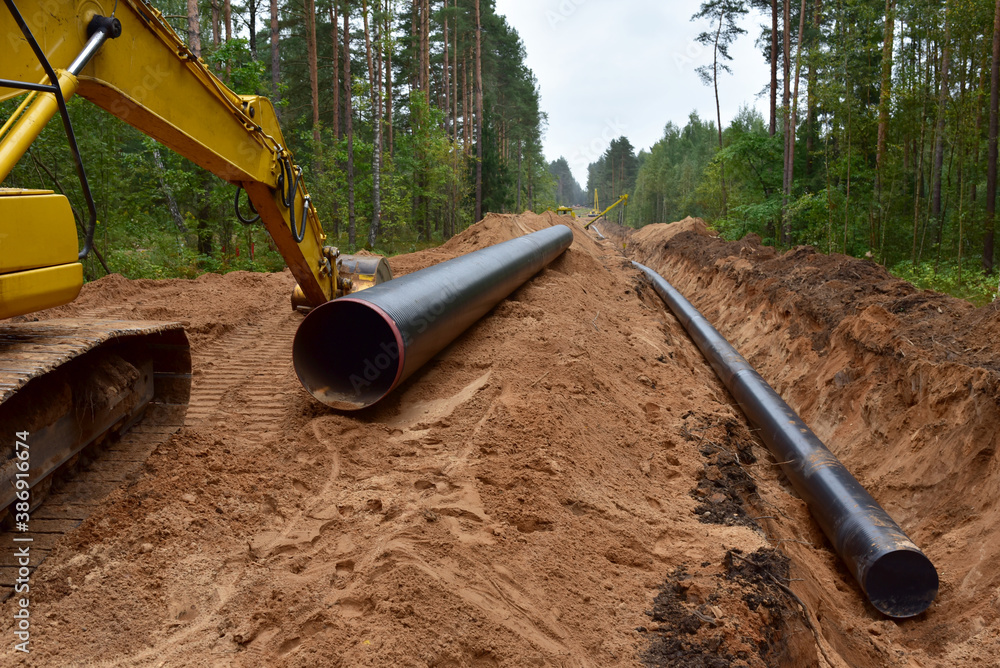 Excavator during earthwork for laying Crude oil and Natural gas ...