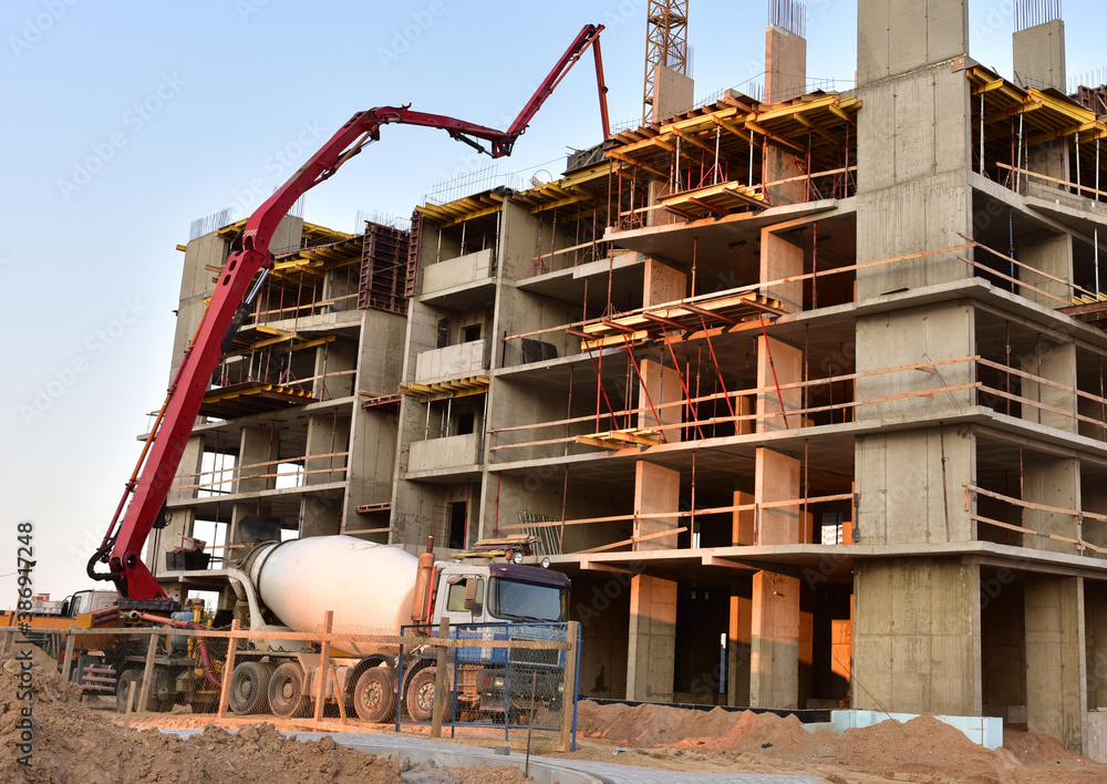 Builder workers during formworks and pouring concrete through a ...