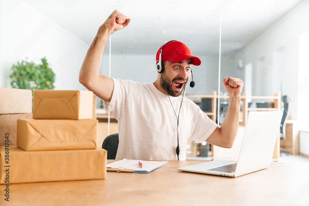 Excited delivery assistance making winner gesture while working in office Excited delivery assistance making winner gesture while working in office