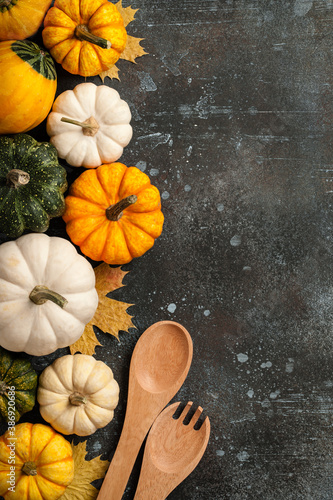 Happy Thanksgiving background with decorative pumpkins and wooden spoons