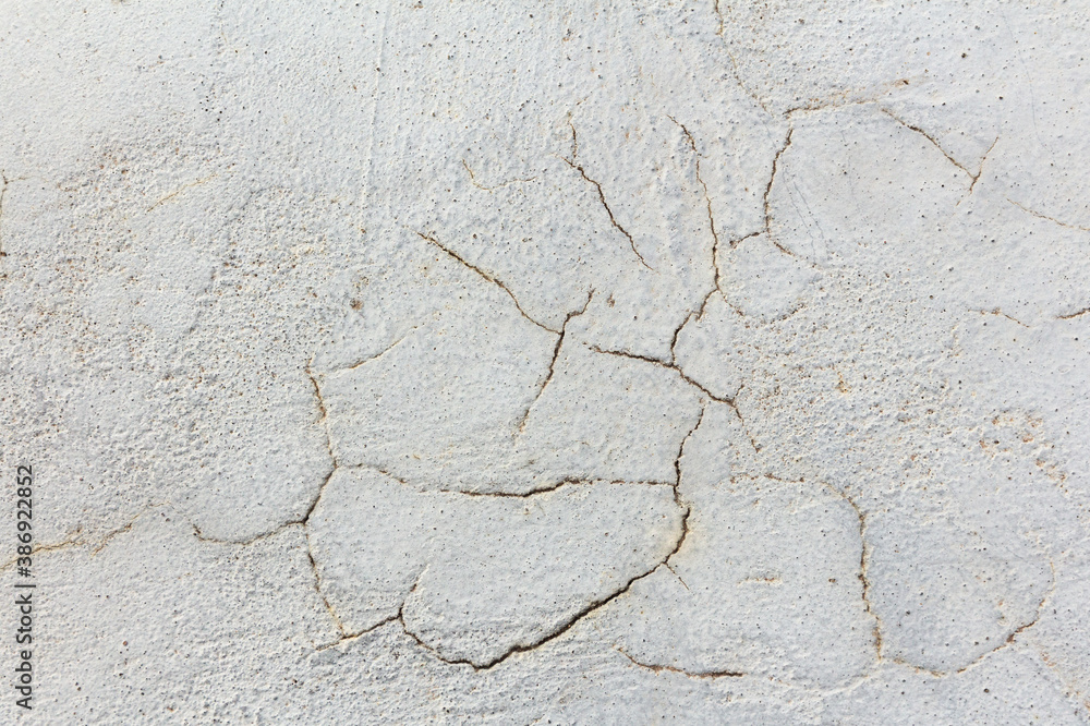 Fototapeta premium Gray plaster wall background with cracks