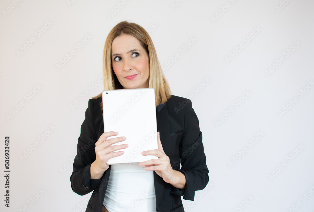 Joyful businesswoman holding a tablet in her hands and smiling Joyful businesswoman holding a tablet in her hands and smiling