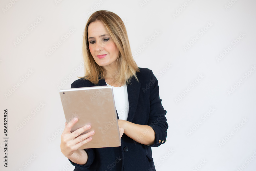 Joyful businesswoman holding a tablet in her hands and smiling Joyful businesswoman holding a tablet in her hands and smiling