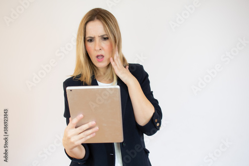 Surprised businesswoman holding a tablet in her hands