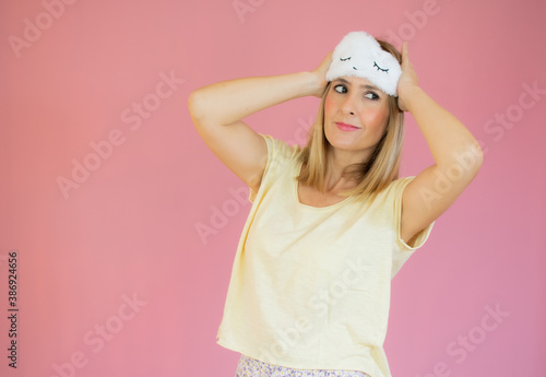 Portrait of sleeping young a woman yawn, stretching and raised hands, waking up at early monday morning standing on pink copy space background