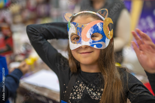 Young girl wearing carnival mask