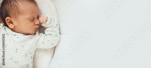 Upper view photo of a newborn baby sleeping well in bed near free space
