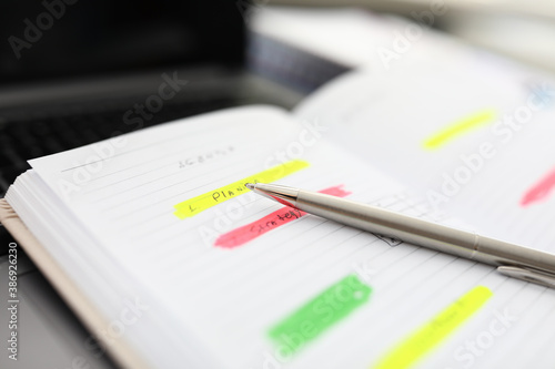 On table is an open diary with notes and pen. Working time scheduling and business tasks concept