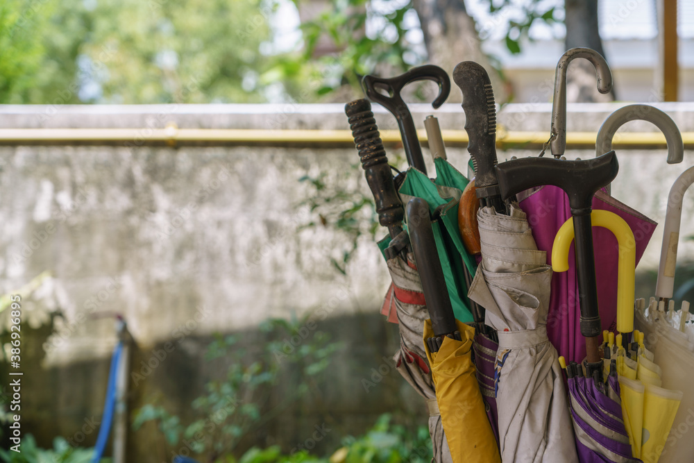 Many umbrellas are placed in the umbrella storage. Each umbrella has a variety of handles. Many umbrellas are placed in the umbrella storage. Each umbrella has a variety of handles.