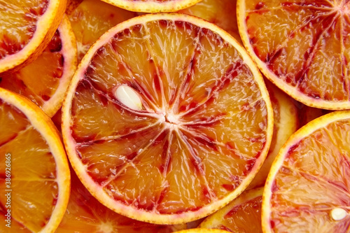 Blood orange slices background, top view. Fresh red orange
