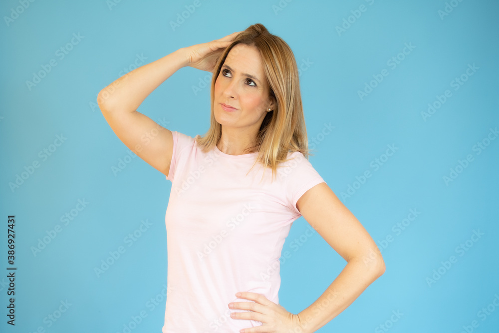 Portrait of a pensive casual woman looking away at copy space isolated over blue background Portrait of a pensive casual woman looking away at copy space isolated over blue background