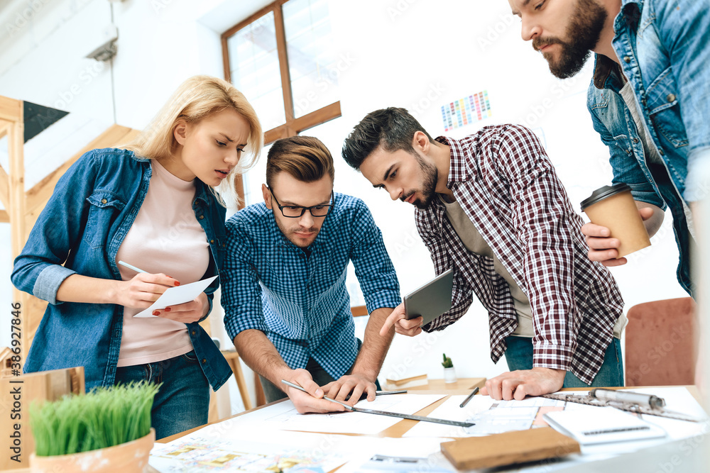 A group of designers stands in the office. A group of designers stands in the office.