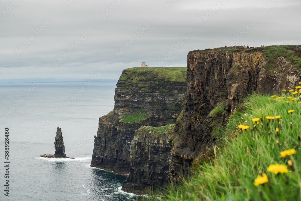 View from Cliff of Moher on Atlantic ocean. County Clare, Ireland. Calm water, cloudy sky.