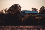 barn on a hill during sunet