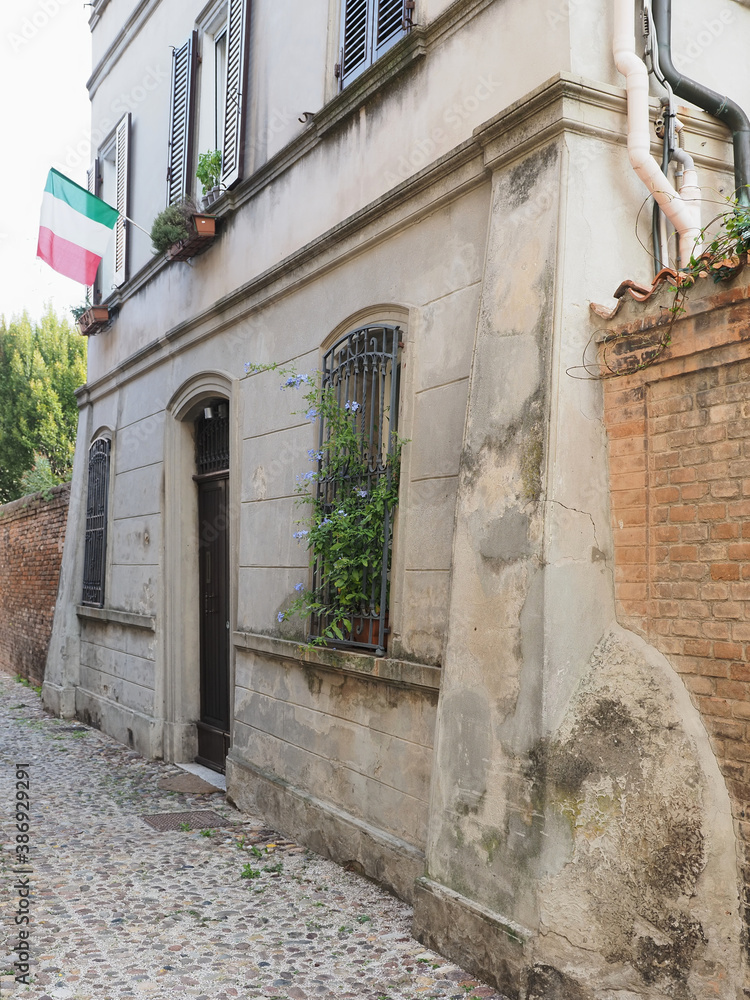 Ferrara, Italy. Old house in the historic center with Italian flag.