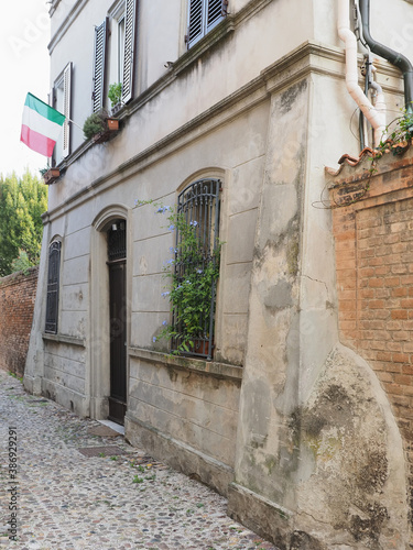 Fototapeta Naklejka Na Ścianę i Meble -  Ferrara, Italy. Old house in the historic center with Italian flag.