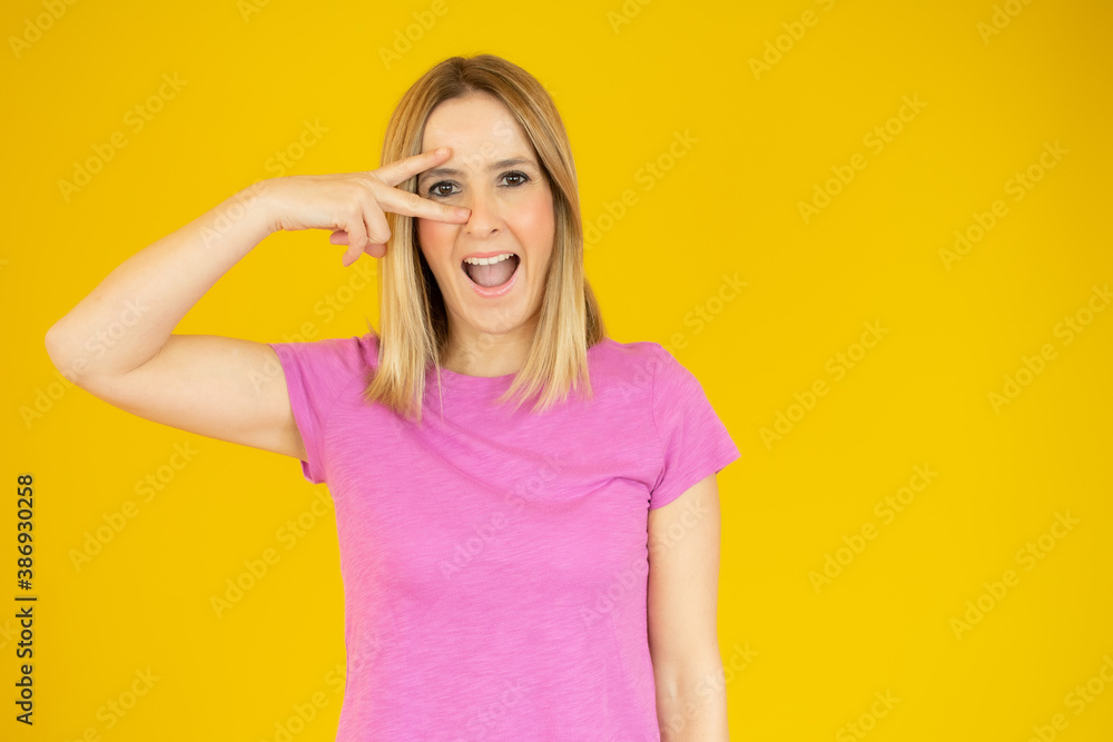 young cool woman covering an eye over yellow background young cool woman covering an eye over yellow background