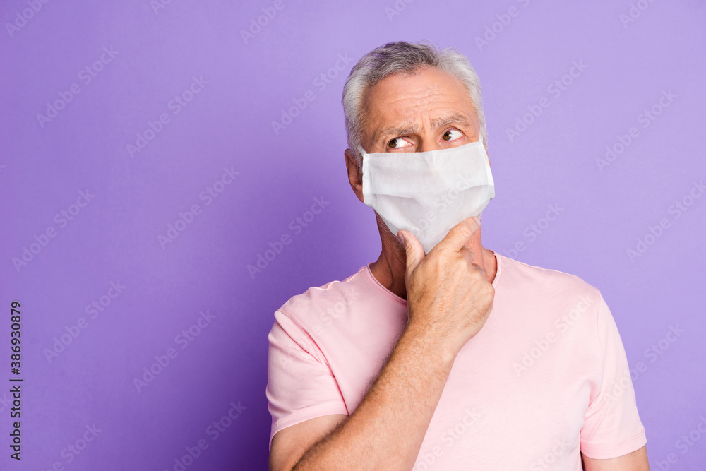 Photo of retired grandfather arm on chin thoughtful look blank space wear white face mask isolated purple color background Photo of retired grandfather arm on chin thoughtful look blank space wear white face mask isolated purple color background