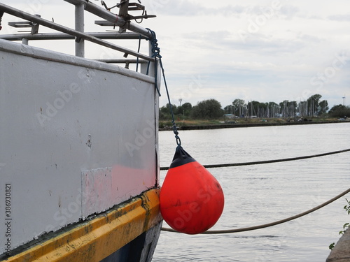 Porto Garibaldi, Italy. Stern of fishing boat with orange fender.