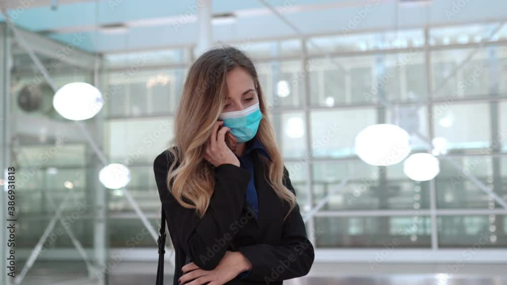 Confident businesswoman in protective face mask using smartphone, talking with someone and waiting for business meeting. Female manager organizing conference during coronavirus pandemic. Portrait of Confident businesswoman in protective face mask using smartphone, talking with someone and waiting for business meeting. Female manager organizing conference during coronavirus pandemic. Portrait of