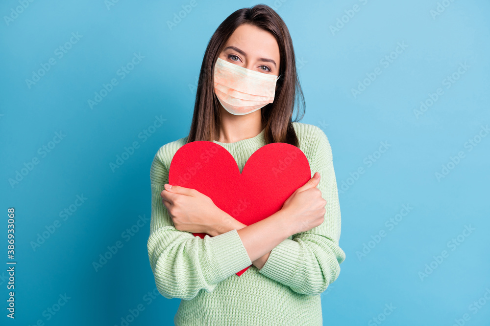 Photo of lovely young girl cuddle red paper heart figure wear orange face mask isolated blue color background - obrazy, fototapety, plakaty 