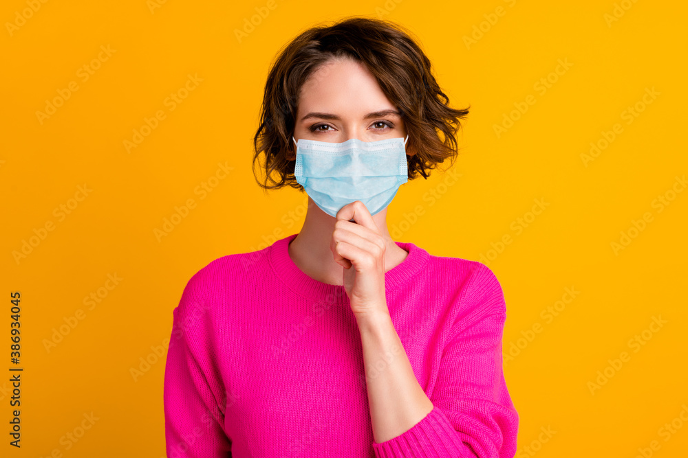 Portrait of minded girl touch chin finger wear blue face mask isolated over vivid yellow color background