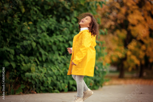 Fototapeta Naklejka Na Ścianę i Meble -  Cute afro girl smiling broadly outdoors and enjoying autumn day in park.