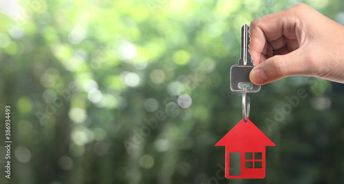 Real estate agent handing over house keys in hand, and coins