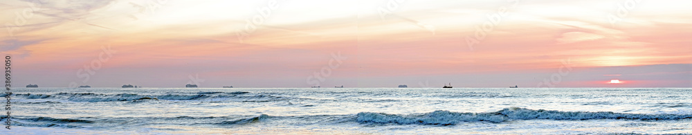 Idle cruise ships parked near the Dutch beach due to Covid pandemic at sunset. 