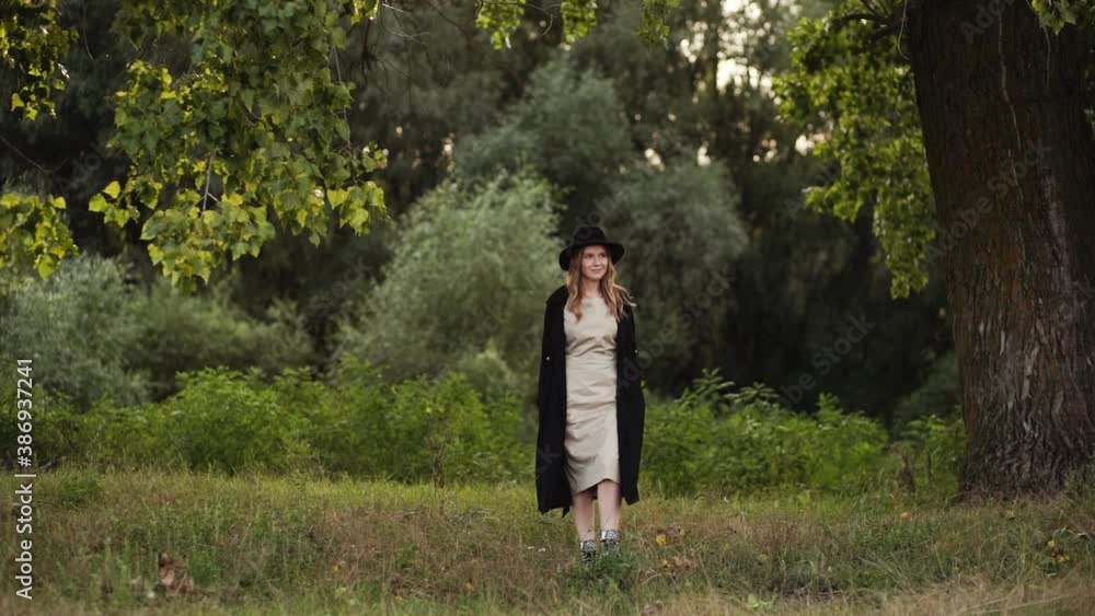 Beautiful young woman walking alone in green fall nature landscape Beautiful young woman walking alone in green fall nature landscape