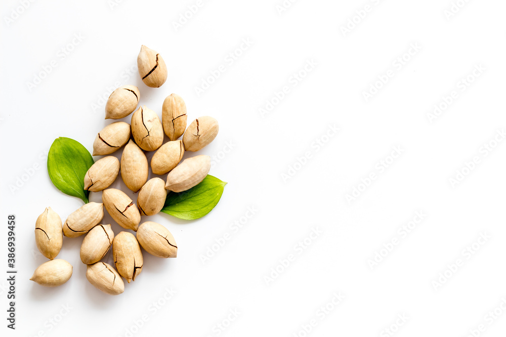 Pile of pecan nuts with leaves. Flat lay, top view Pile of pecan nuts with leaves. Flat lay, top view