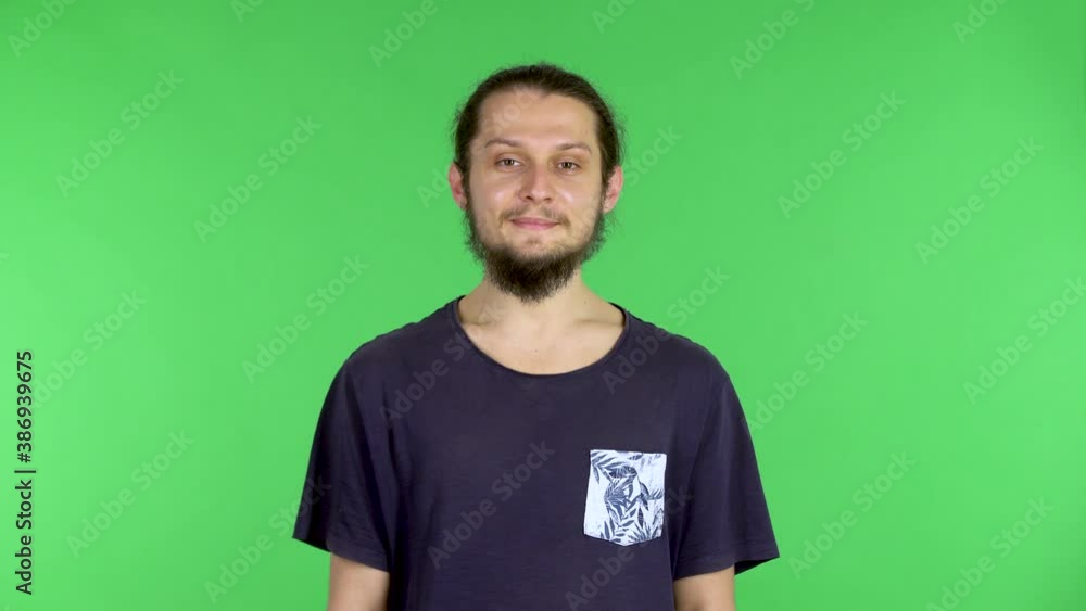 Young man in green room and looks at the camera, chroma key background, a man smiles, positive emotions. Young man in green room and looks at the camera, chroma key background, a man smiles, positive emotions.
