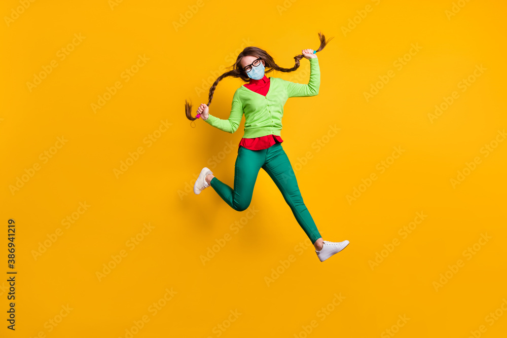 Full length body size view of funky cheerful girl jumping running holding pigtails wear mask isolated bright yellow color background