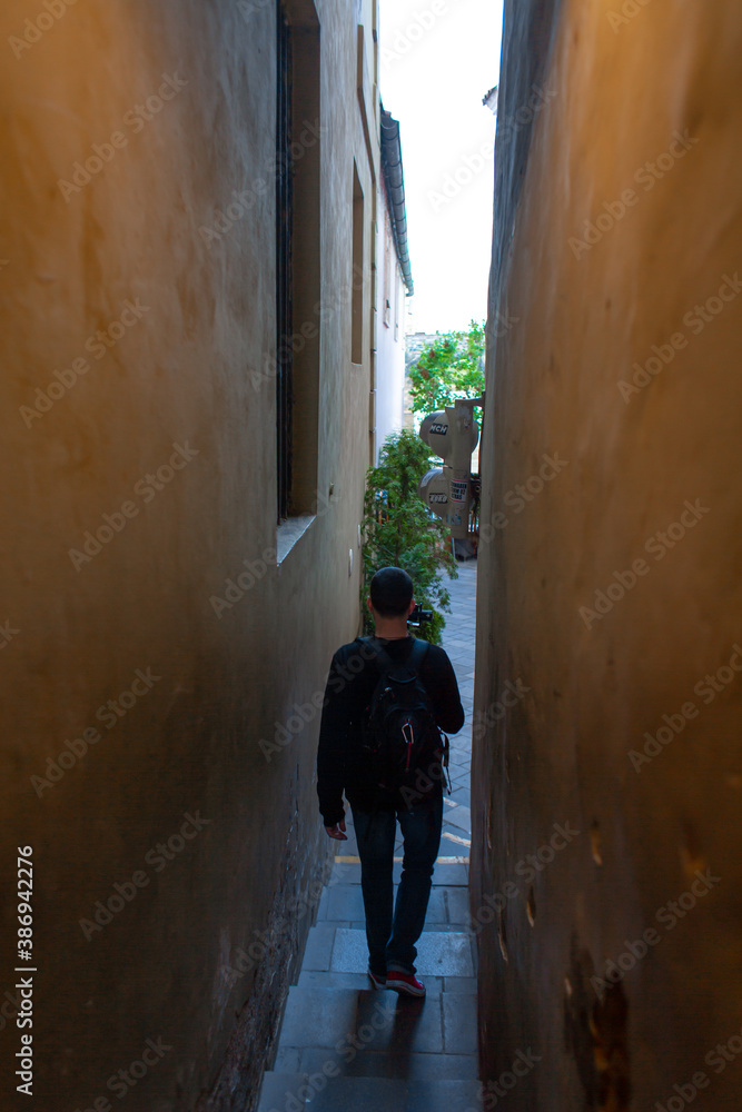 The architecture of the strago city of Prague. The narrowest street in Europe. The passage between buildings for one person, regulated by traffic lights The architecture of the strago city of Prague. The narrowest street in Europe. The passage between buildings for one person, regulated by traffic lights