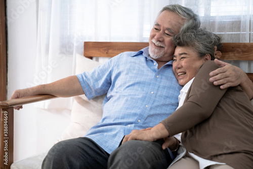 Happy and smiling Asian couple while sitting on sofa at home, Lifestyle after retiree.