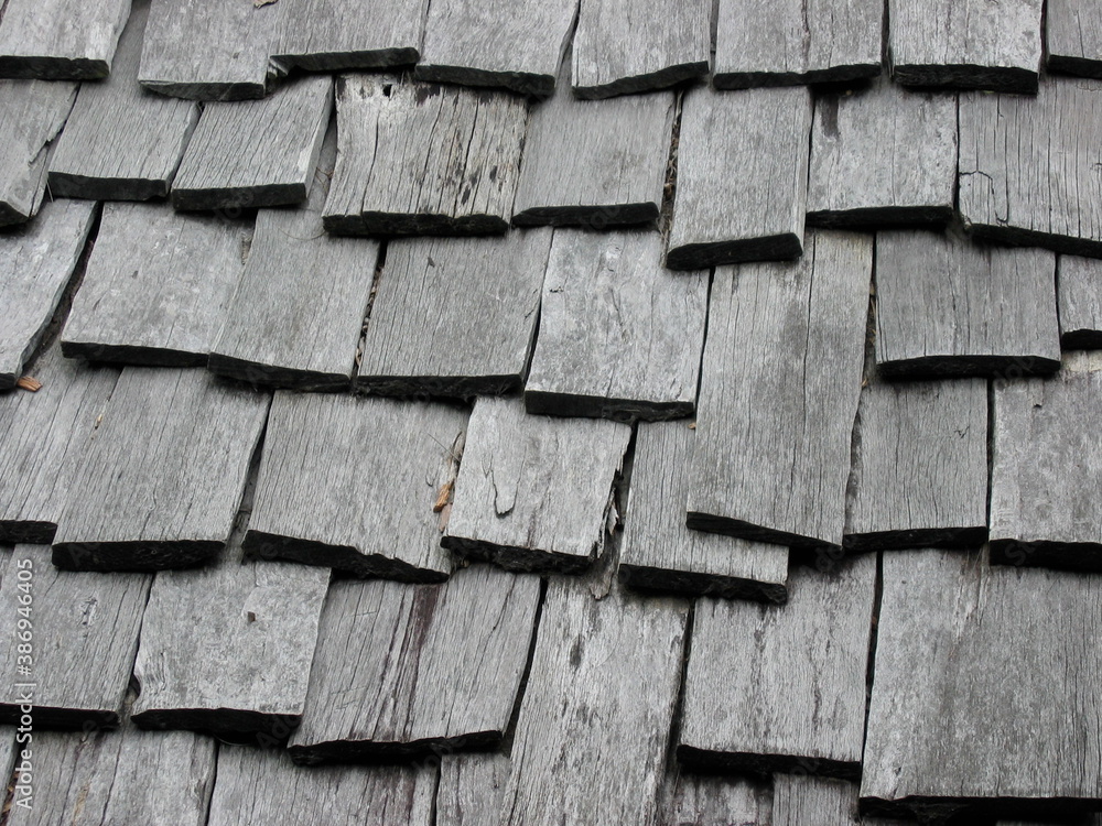 Weathered wooden roof composed of overlapping wooden boards. Rough and uniform texture. Weathered wooden roof composed of overlapping wooden boards. Rough and uniform texture.