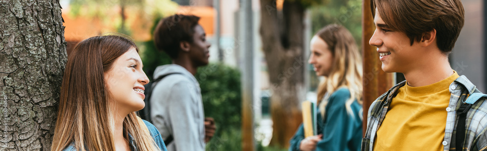 Website header of teenagers talking near tree outdoors Website header of teenagers talking near tree outdoors