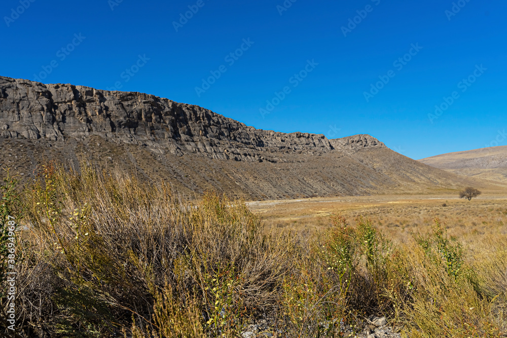 Mountains in the fall. Karatau mountains in southern Kazakhstan. Mountain plants in autumn. Rocks. Mountain stones. Rocks. Dry grass. Blue sky