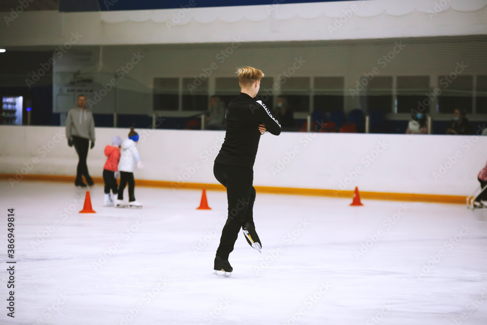 Figure skating school. Figure skater practicing at indoor skating rink