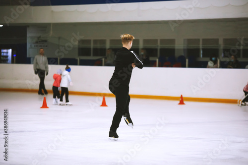 Figure skating school. Figure skater practicing at indoor skating rink. Man learning to ice skate. Jumps