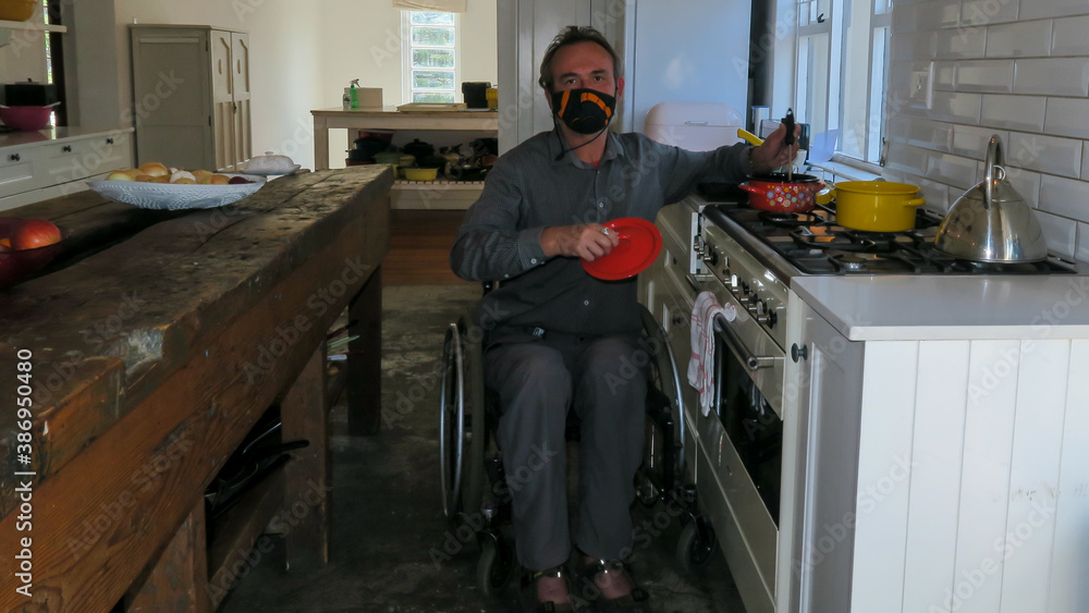 Man in a wheelchair  stirring food in a red pot