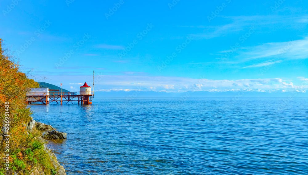 bright lighthouse on the shore of lake Baikal on a clear Sunny autumn day